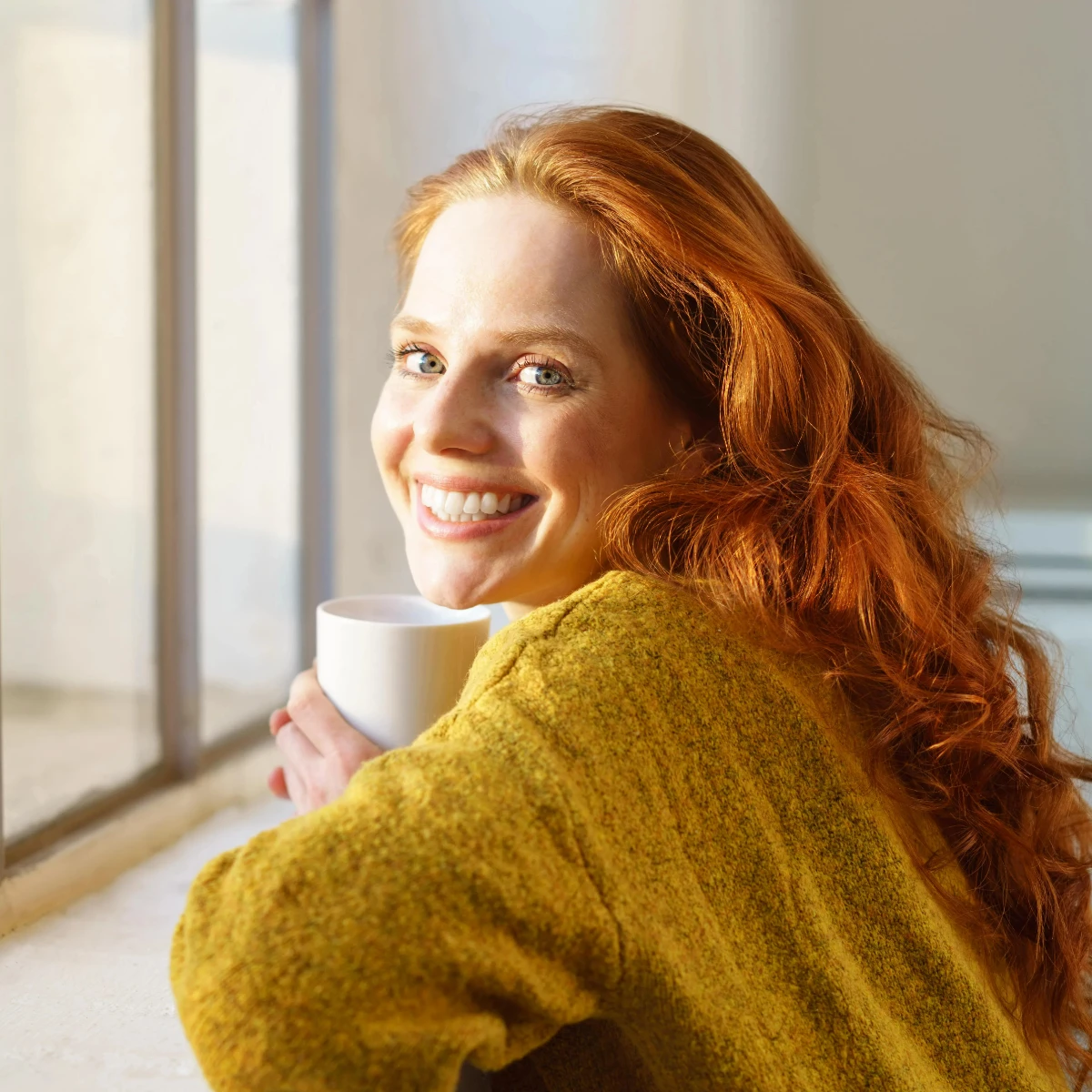  Entspannte frau steht am Fenster und genießt eine Tasse Tee 