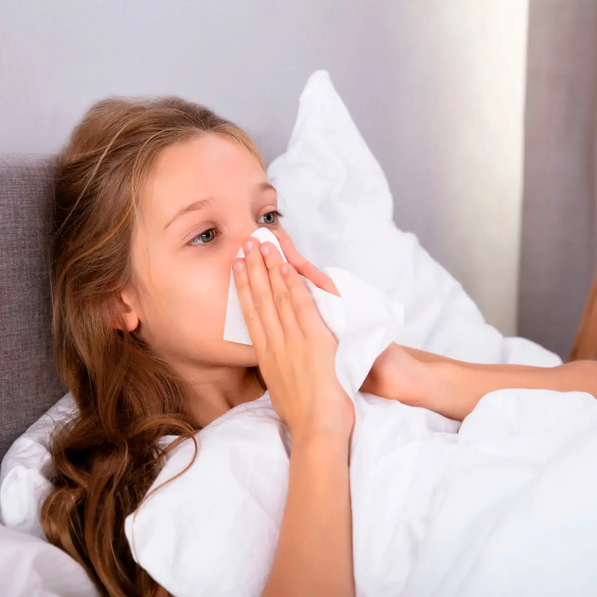  Kind mit Erkältung schnäuzt sich 