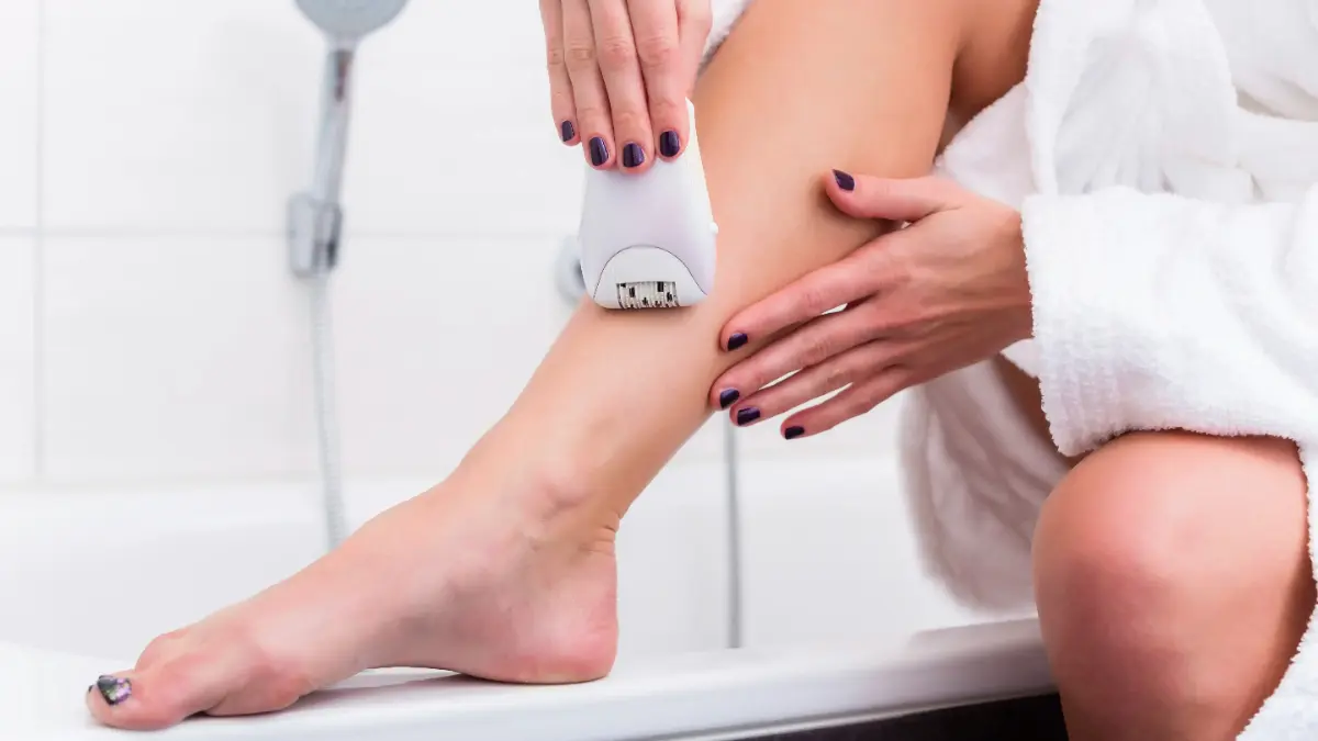  Frau epiliert sich die Beine 