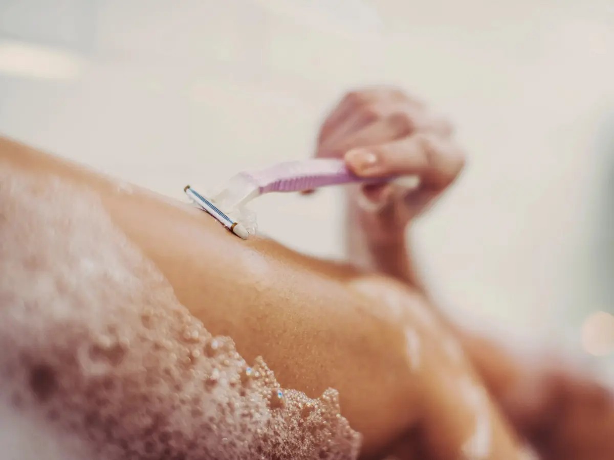  Frau rasiert sich die Beine 