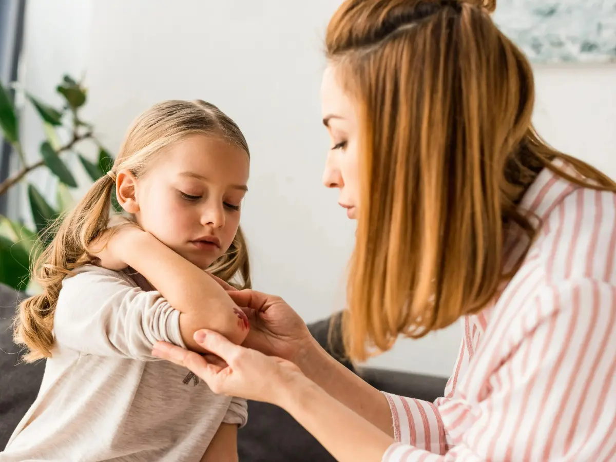  Mutter versorgt Wunde ihrer Tochter 