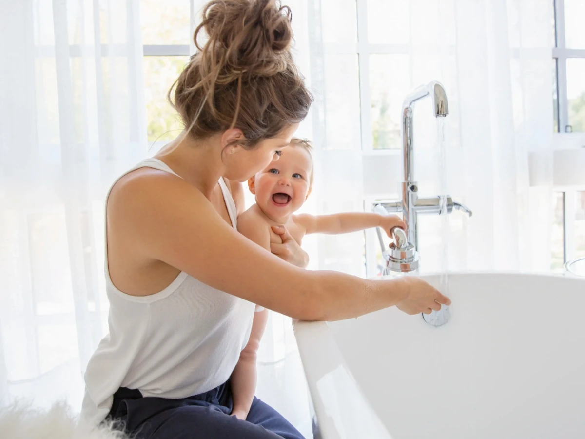  Mutter bereitet Bad für Kind vor 