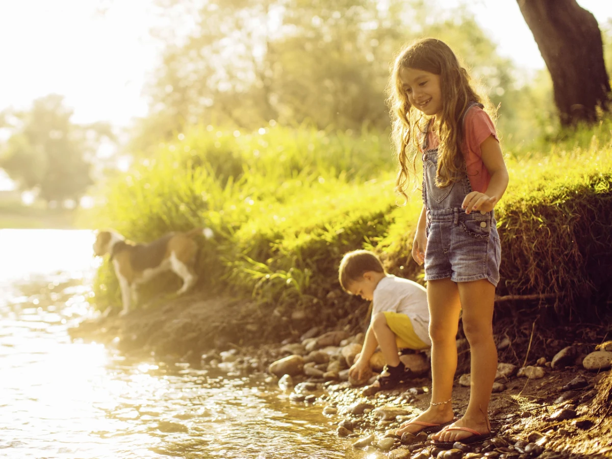  Kinder spielen am Flussufer 