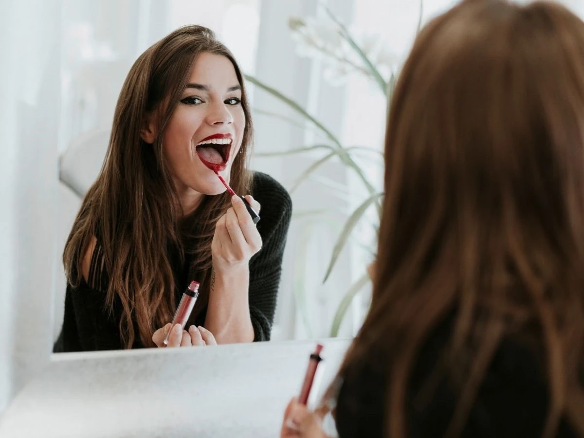  Frau trägt Lippenstift auf 