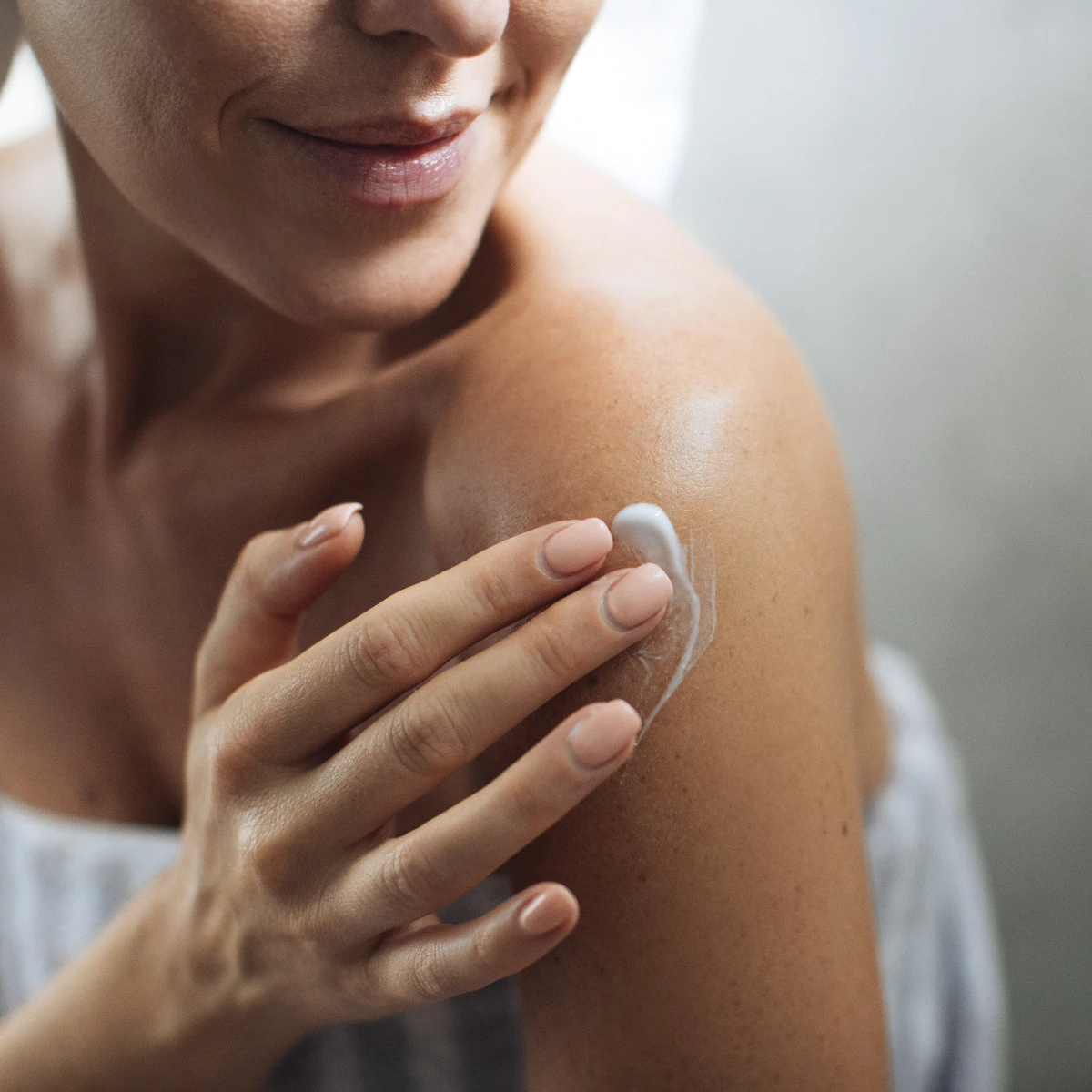  Frau trägt Bodylotion auf 