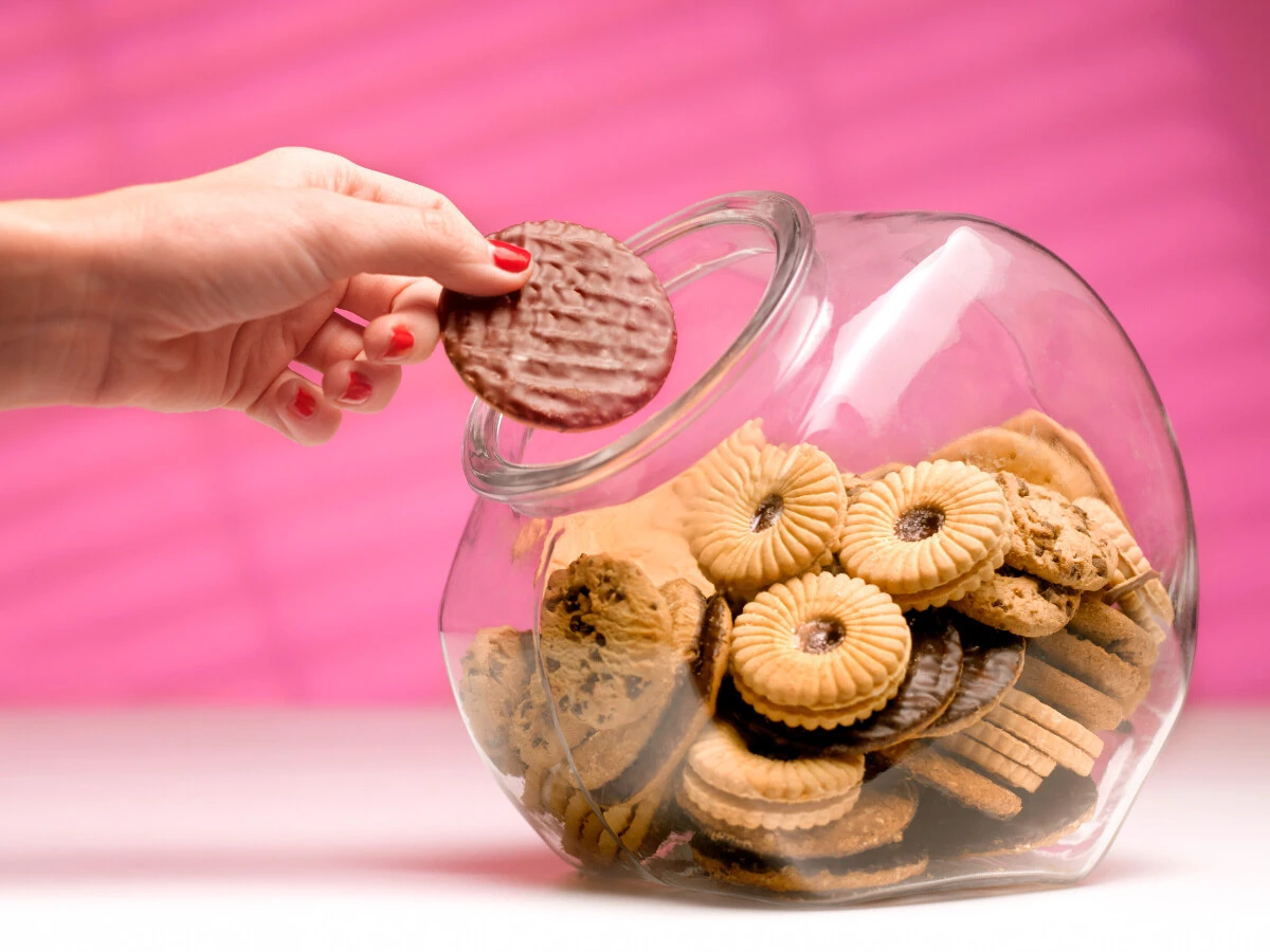  Frau greift in Keksdose 