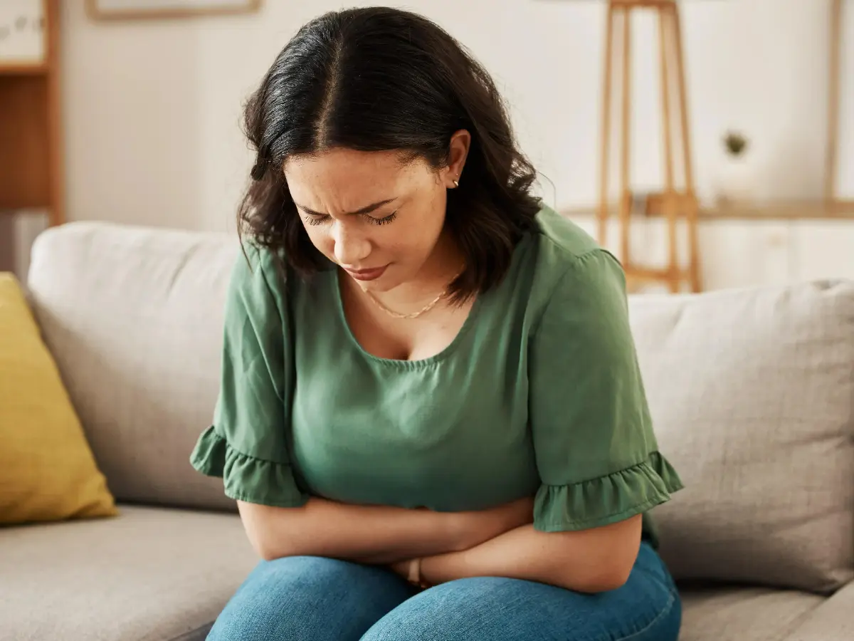  Frau mir Bauchschmerzen auf der Couch 