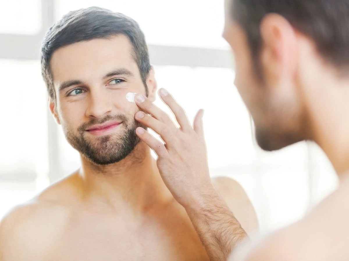  Mann trägt Gesichtscreme auf 