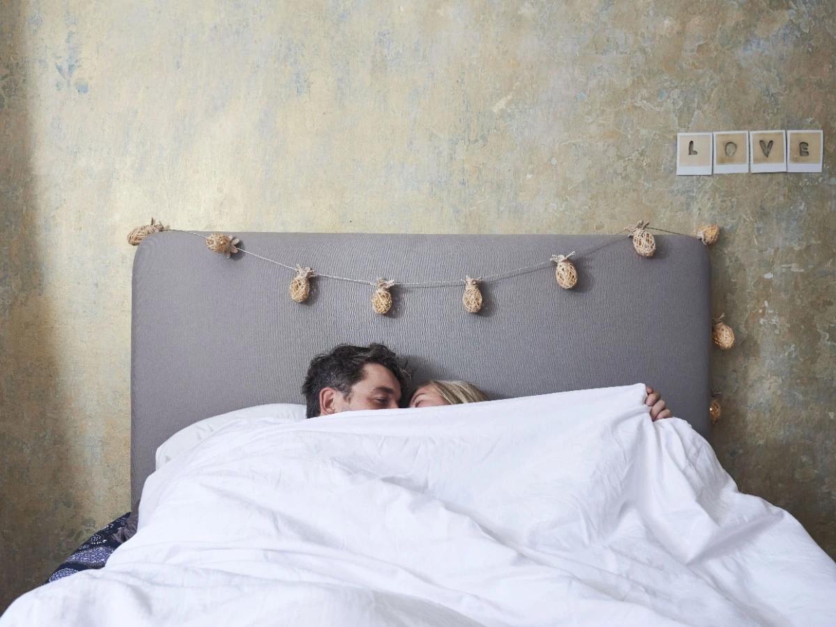  Pärchen kuschelt im Bett unter der Decke 