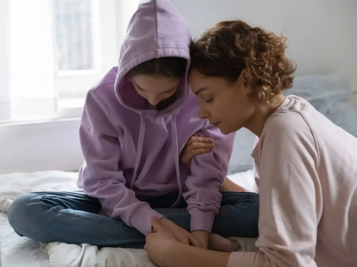  Mutter tröstet trauriges Kind 