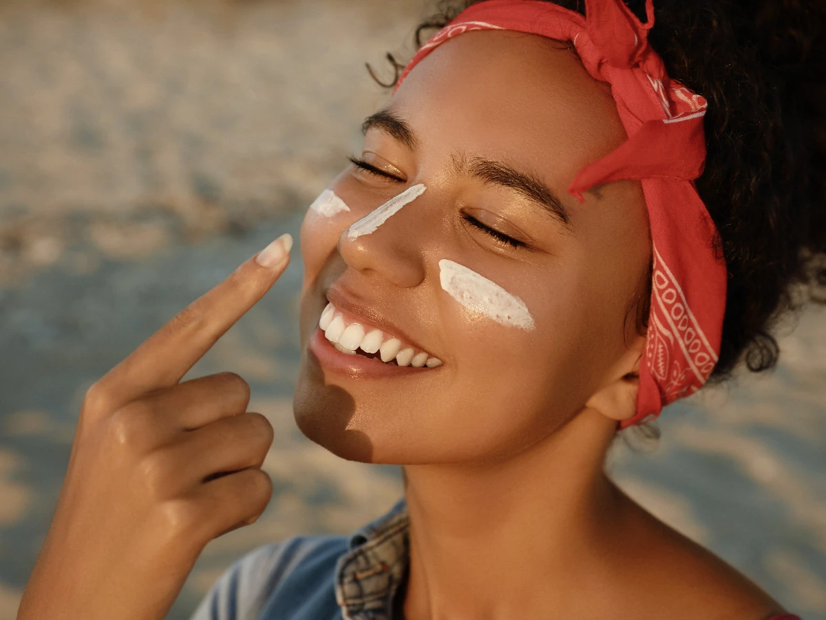  Frau trägt Sonnenschutz im Gesicht auf 
