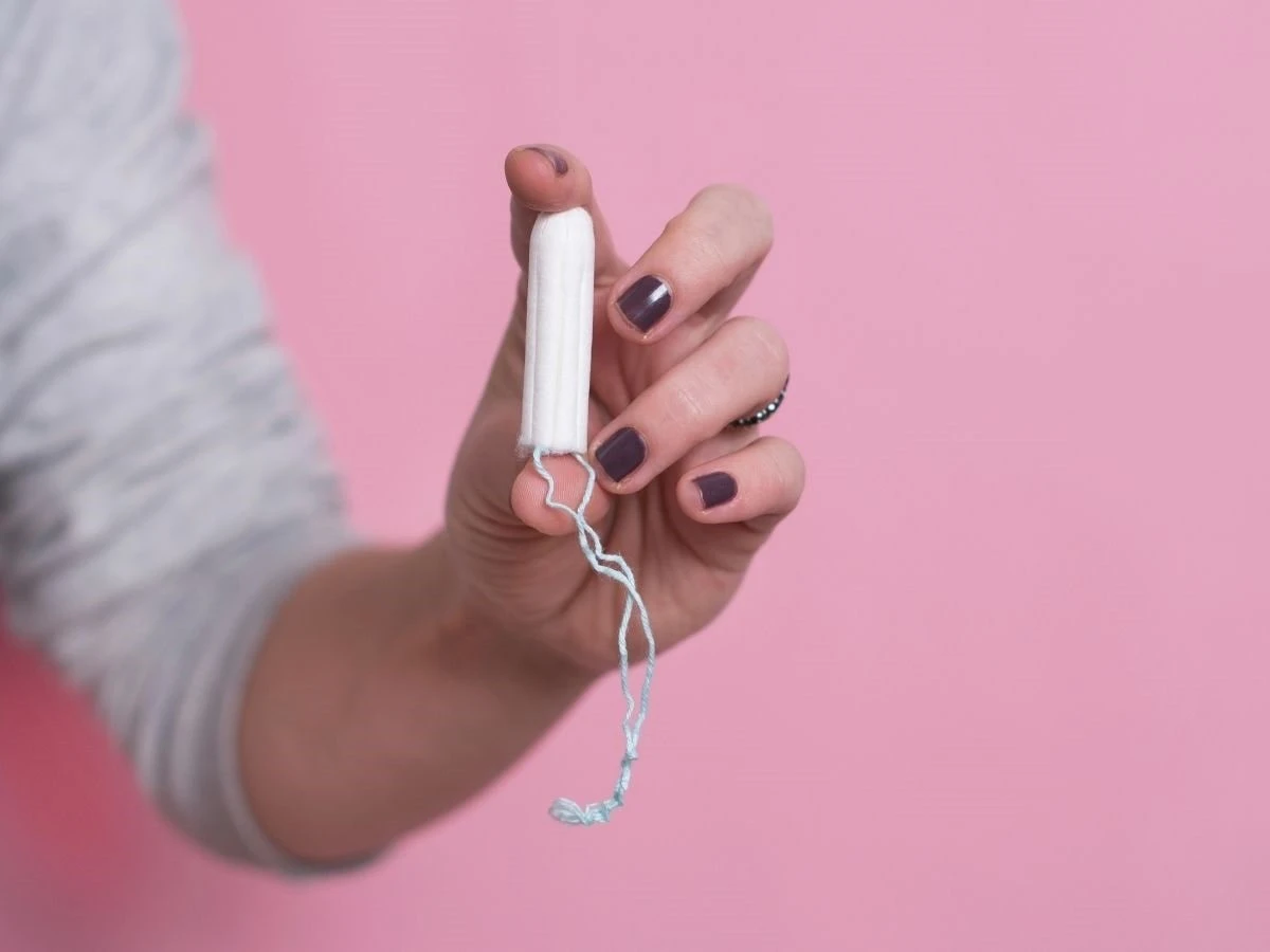  Frauenhand hält ein Tampon 