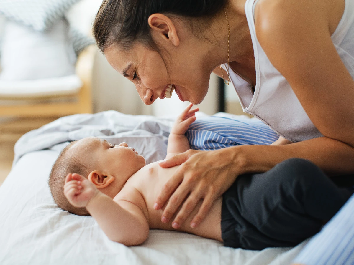  Junge Mutter spielt zu Hause mit ihrem 5 Monate alten Baby. 