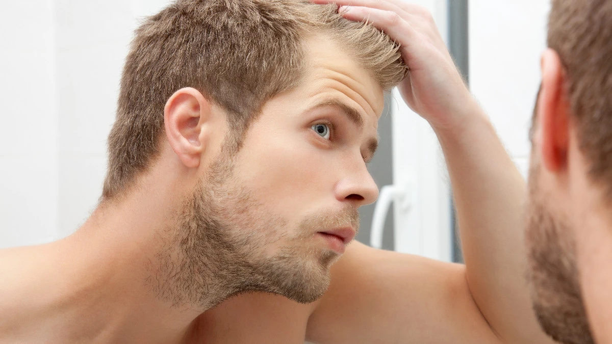  Mann sieht sich im Spiegel an 