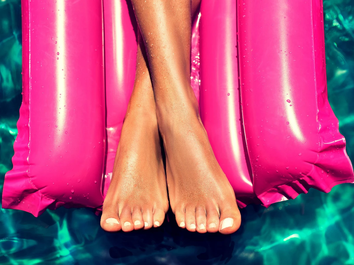  Gepflegte Füße gekreuzt auf der Matratze. 