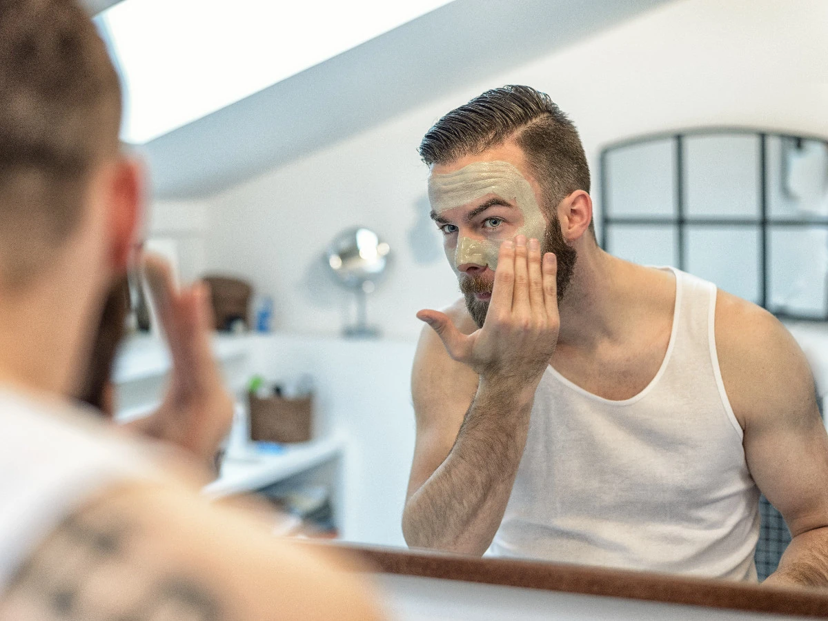  Mann mit Bart trägt Gesichtsmaske auf 