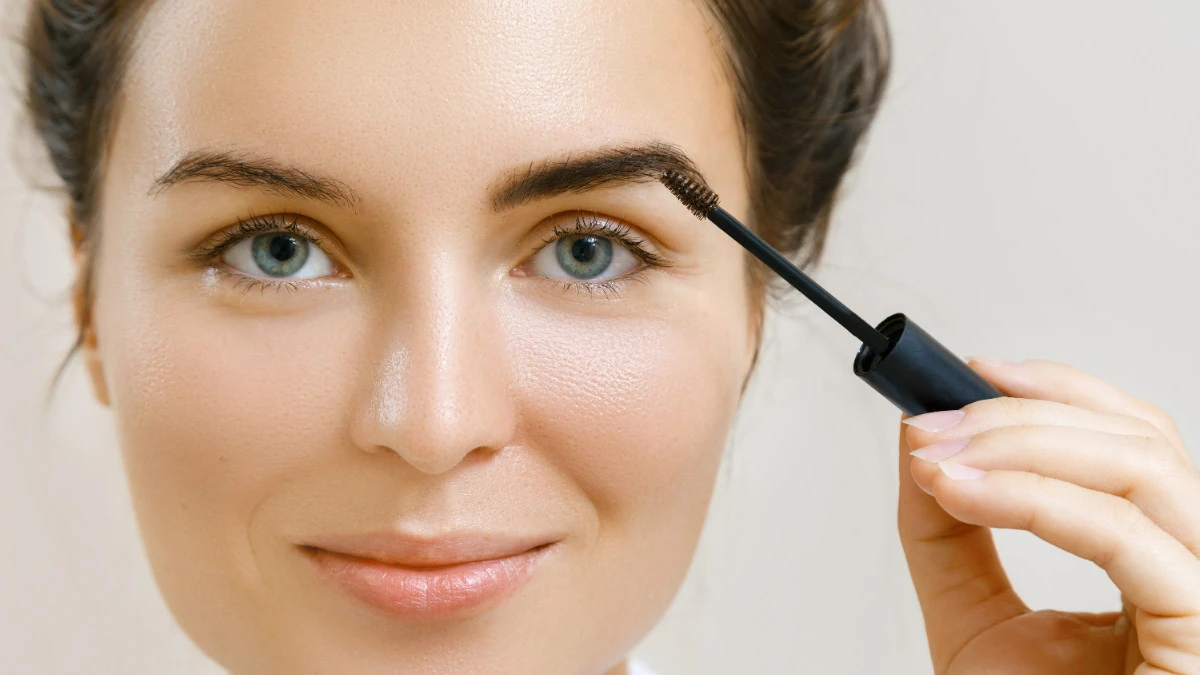  Frau trägt Augenbrauen Gel auf 