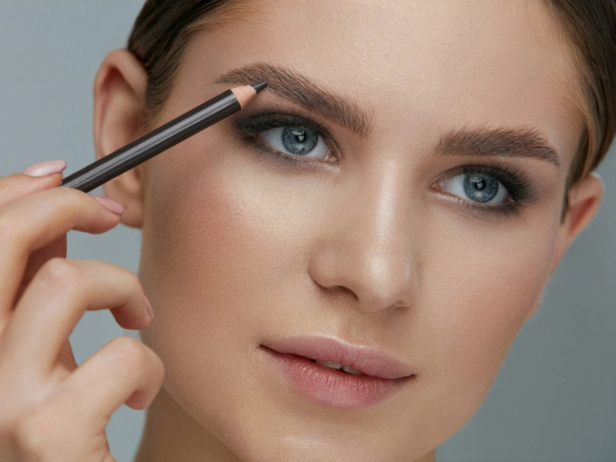  Frau trägt Augenbrauenstift  auf 